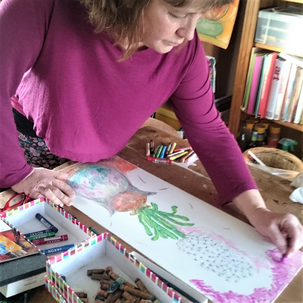 Artist Susan Marie Williams in art studio drawing a hyacinth artwork with oil pastels
